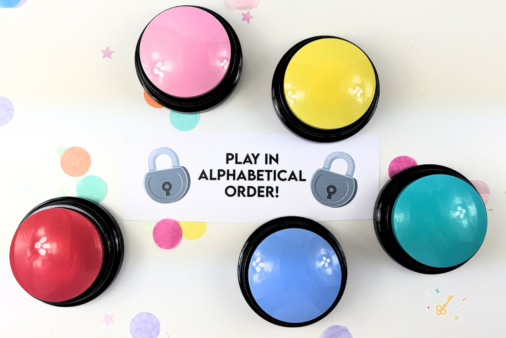 Five different colored recordable push buttons. with a piece of paper that reads "play in alphabetical order!".