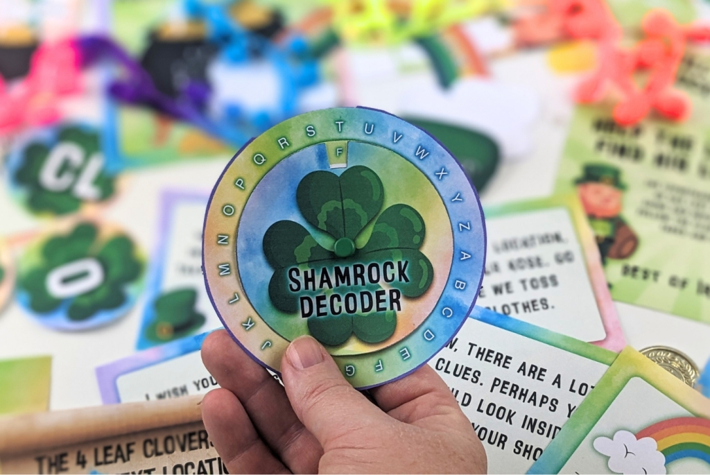 A hand holding a shamrock decoder wheel with puzzles in the background.