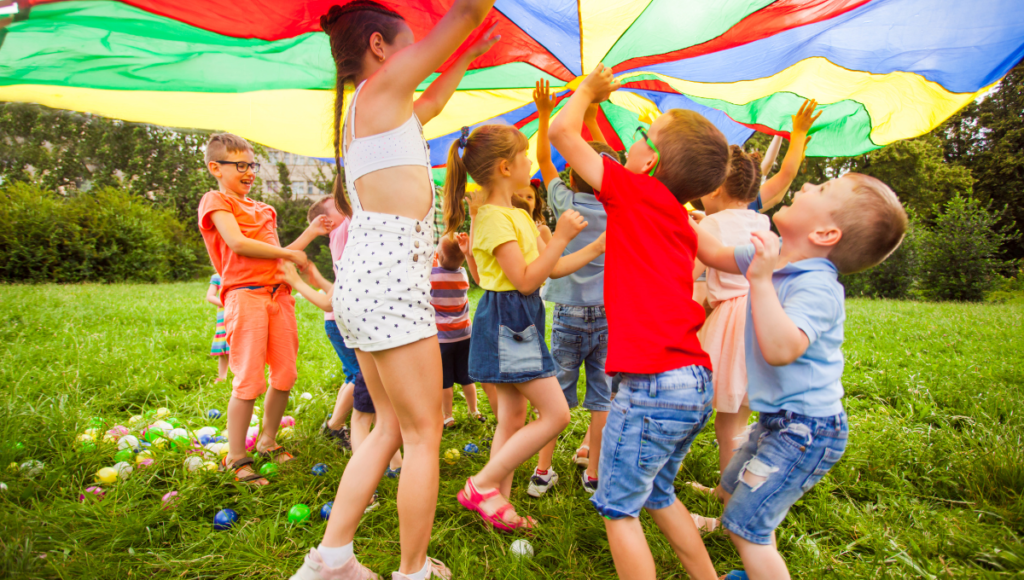 kids having fun with outdoor activities using a parachute silk.