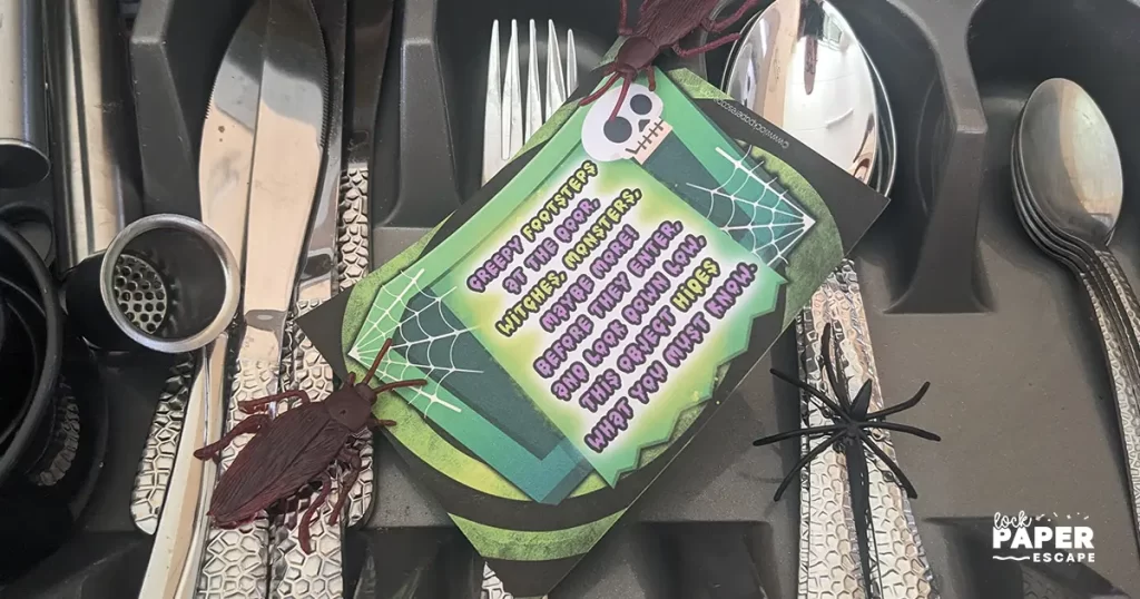 Halloween treasure hunt printable, Clue hidden inside a cutlery drawer with plastic creepy crawlies, spooky kids’ activity.